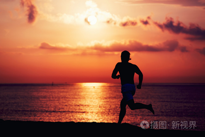 肌肉结实运动员跑得快的日志海滩,转轮在行动在海上