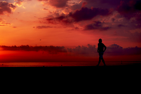 在橘红色的日出，男运动员与肌肉发达的身体，在早上慢跑 有吸引力慢跑者在行动 健身和健康的生活方式的概念对海滩上慢跑运动转轮的