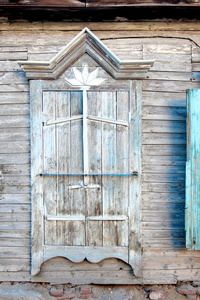 俄罗斯贫民窟小屋的旧的过时的木窗。闭合百叶窗