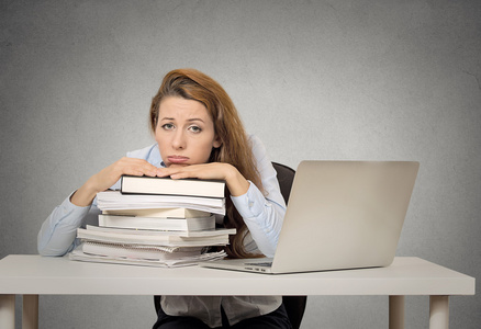 缺乏安全感动力感到厌烦的女学生,坐在办公桌前照片