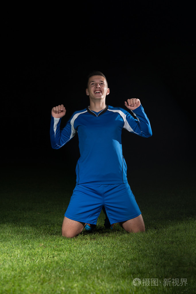 足球运动员庆祝在黑色背景上的胜利