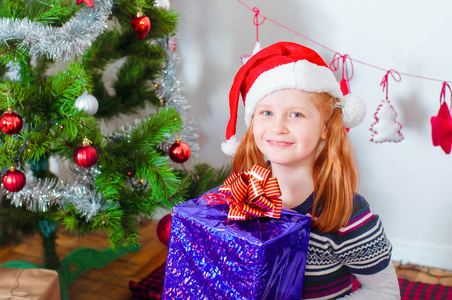 小女孩附近与礼物的圣诞树
