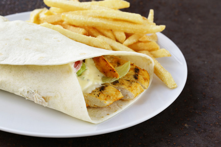 墨西哥鸡肉卷和酱和炸薯条照片