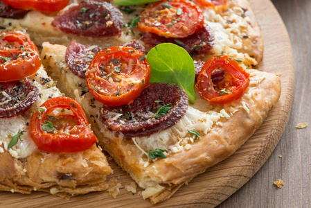 美味的比萨，意大利腊肠，西红柿在木板上