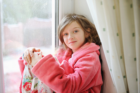 漂亮的小女孩，在靠近窗口的浴袍