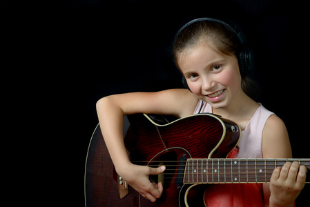 弹吉他的漂亮的小女孩
