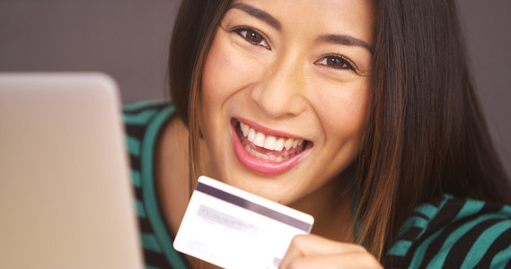 幸福的日本女人，微笑着用信用卡的特写