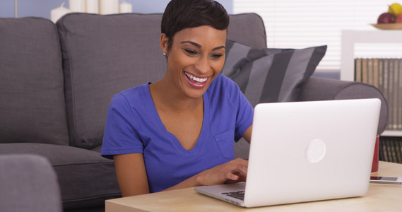 幸福的非洲女人快乐使用便携式计算机