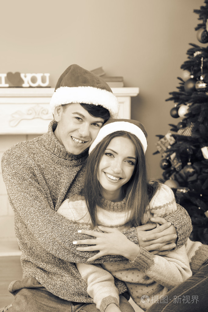 好爱附近圣诞树的情侣.女人和男人庆祝圣诞节