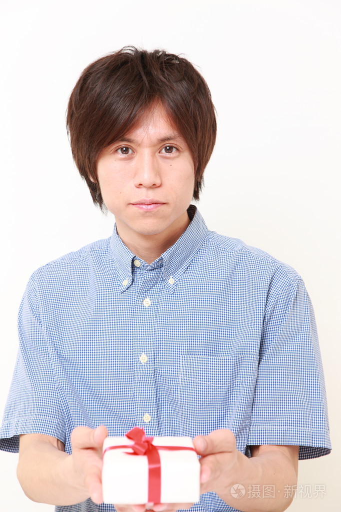 年轻的日本人提供一份礼物照片-正版商用图片1h6mt5-摄图新视界