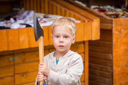 小男孩拿着一把木制的斧头
