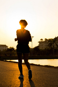 跑步运动员脚在道路上运行。女人健身剪影苏