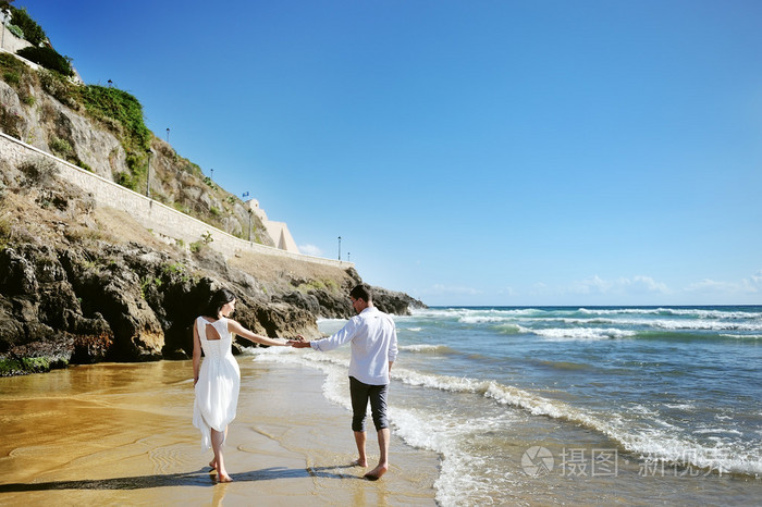 夫妻在一起手牵手的海滩上散步