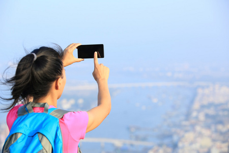 年轻女子的徒步旅行者使用智能手机