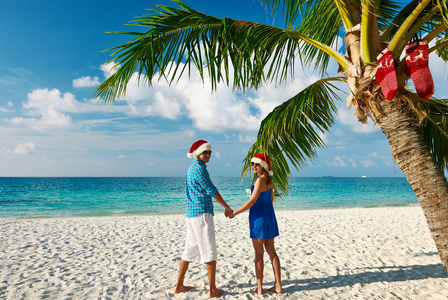 在圣诞节情侣在热带的海滩上