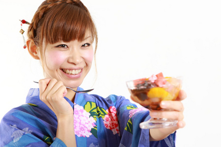 年轻女人穿着和服在日本传统的豆果酱甜点