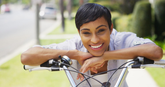 非洲的女人微笑，斜倚在自行车车把