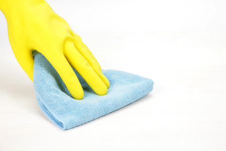 Hand with rubber glove wiping with a cloth