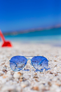 热带海滩上多彩蓝色太阳镜的特写