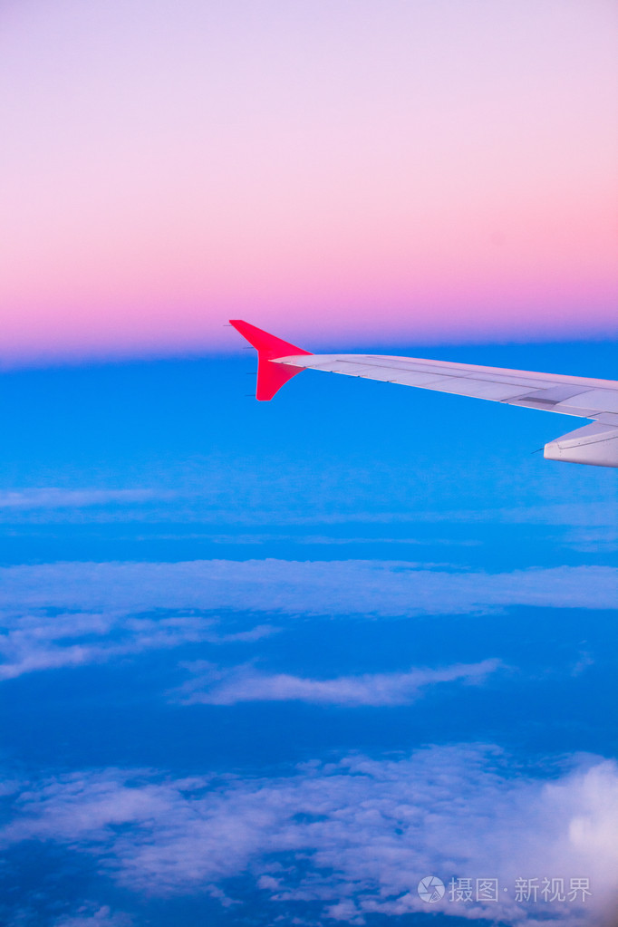 色彩斑斓的天空在云层上面飞行飞机机翼