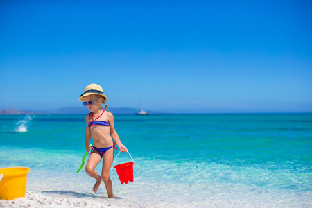 可爱的小女孩在地处热带的海滩和沙滩玩具乐子