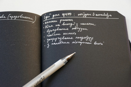 笔记本用黑纸和打开详细页和白底黑字的白色钢笔