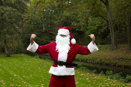 圣诞老人在公园里展示他的肌肉