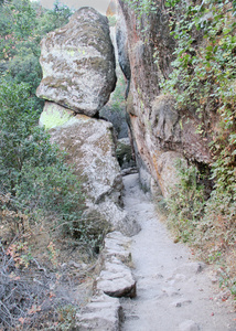 倾斜岩石悬空下的徒步小道