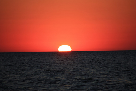 海滩太阳水天气海水波涛汹涌的人天空假日太阳下日落