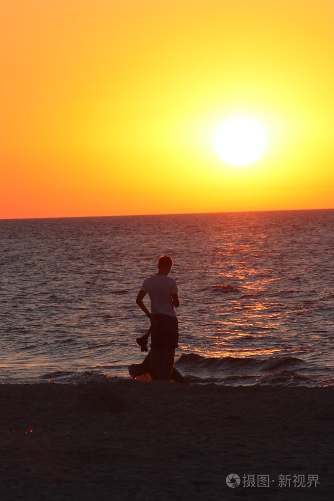 海滩太阳水天气海水波涛汹涌的人天空假日太阳下日落