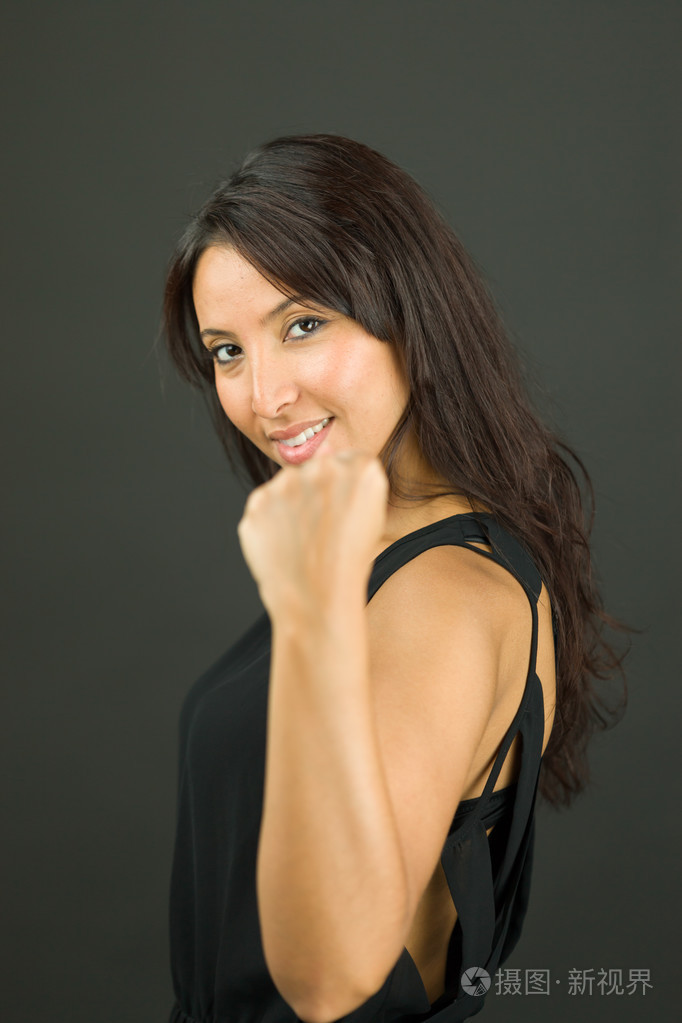 兴奋的年轻女人显示拳头和庆祝成功