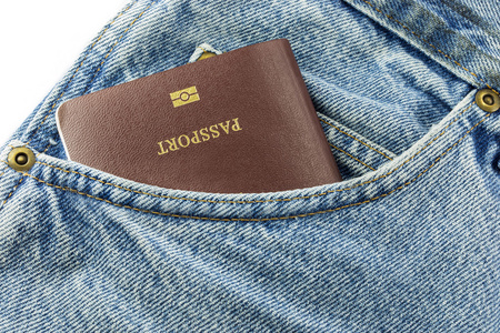信用卡和护照在牛仔裤的蓝色斜纹粗棉布牛仔裤的特写