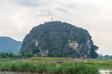 一座陡峭的小山在绿色的田野