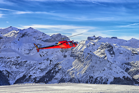 红色的直升机降落在瑞士滑雪胜地附近少女峰白雪皑皑