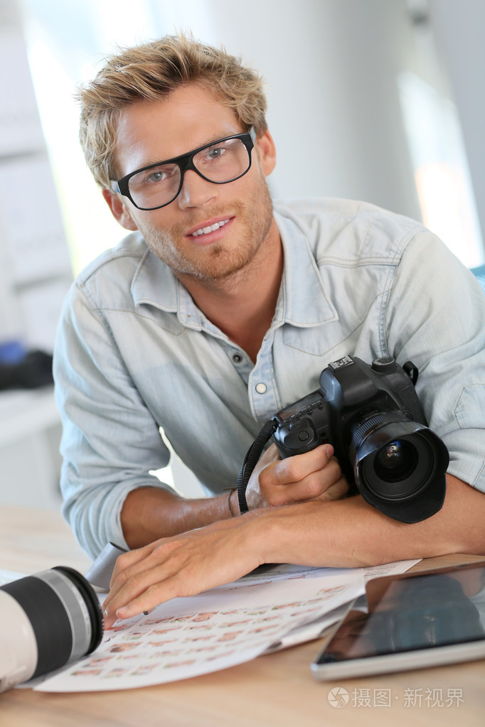 年轻的摄影师记者在办公室