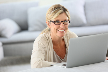 与眼镜 websurfing 笔记本电脑上的女人