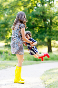 妈妈和小可爱儿童女孩在橡胶靴玩乐