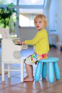 小女孩在玩钢琴玩具在家里