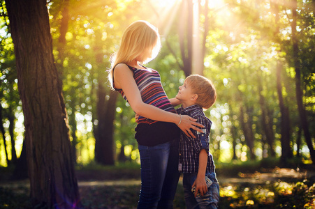 母亲和小儿子在公园或森林，在户外。拥抱和 h