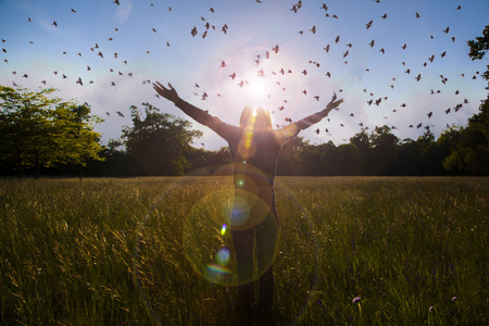 年轻女孩传播与喜悦和面对太阳，太阳问候 自由理念，象征着自由和自由飞翔的鸟的灵感的手