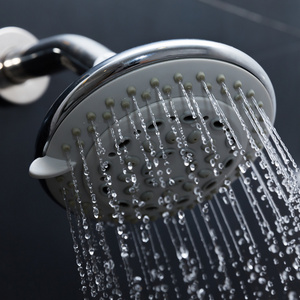 淋浴头在浴室用水一滴滴流淌照片