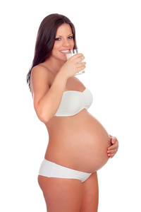 有吸引力的黑发孕妇在喝牛奶的内衣