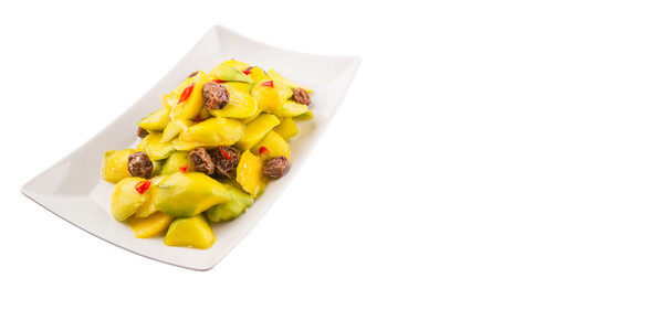 马来西亚人的素食小吃Jeruk Mangga Muda Asamboi或腌制的小芒果，上面有干的罗望子和白色盘子里的辣椒片。