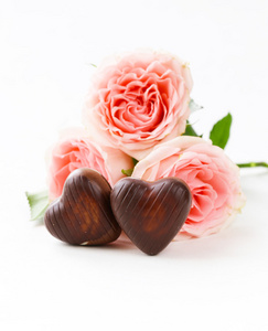 巧克力糖果形状的心和粉红玫瑰为情人节假期