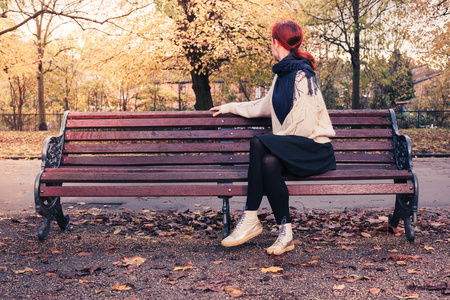 年轻女子坐在公园的长椅上