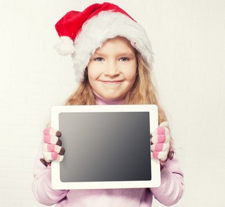 孩子在圣诞帽子的平板电脑图片