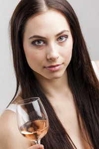 一杯玫瑰红酒的年轻女子的画像