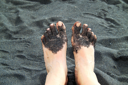 脚在黑色沙子范围
