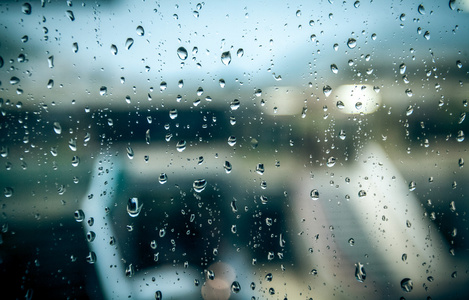 潮湿的街道在雨天通过窗口与水滴