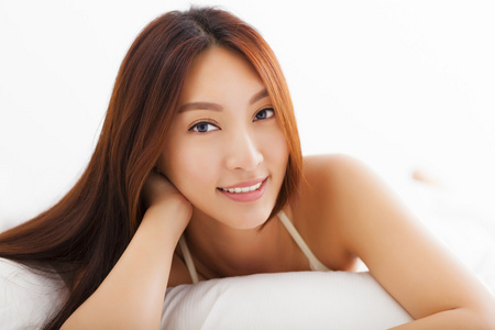年轻漂亮的亚洲女人躺在床上，